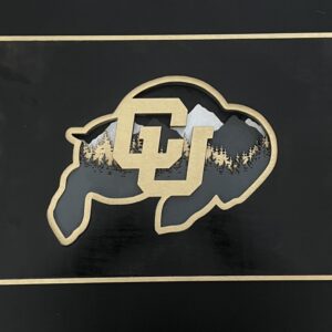 7-layered laser cut mountain scene in the shape of the CU Buffalo. Black, Gold, Gray and Silver.