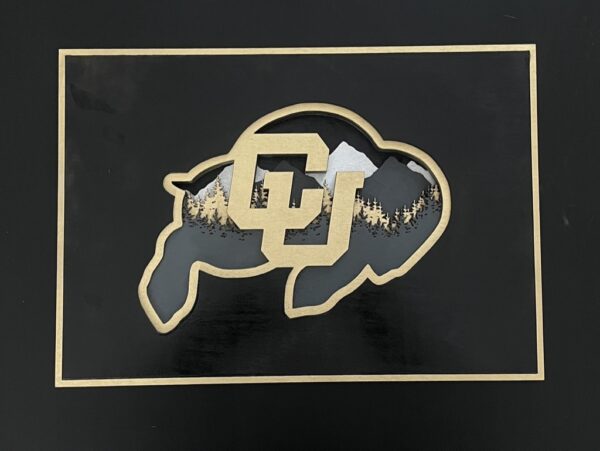 7-layered laser cut mountain scene in the shape of the CU Buffalo. Black, Gold, Gray and Silver.